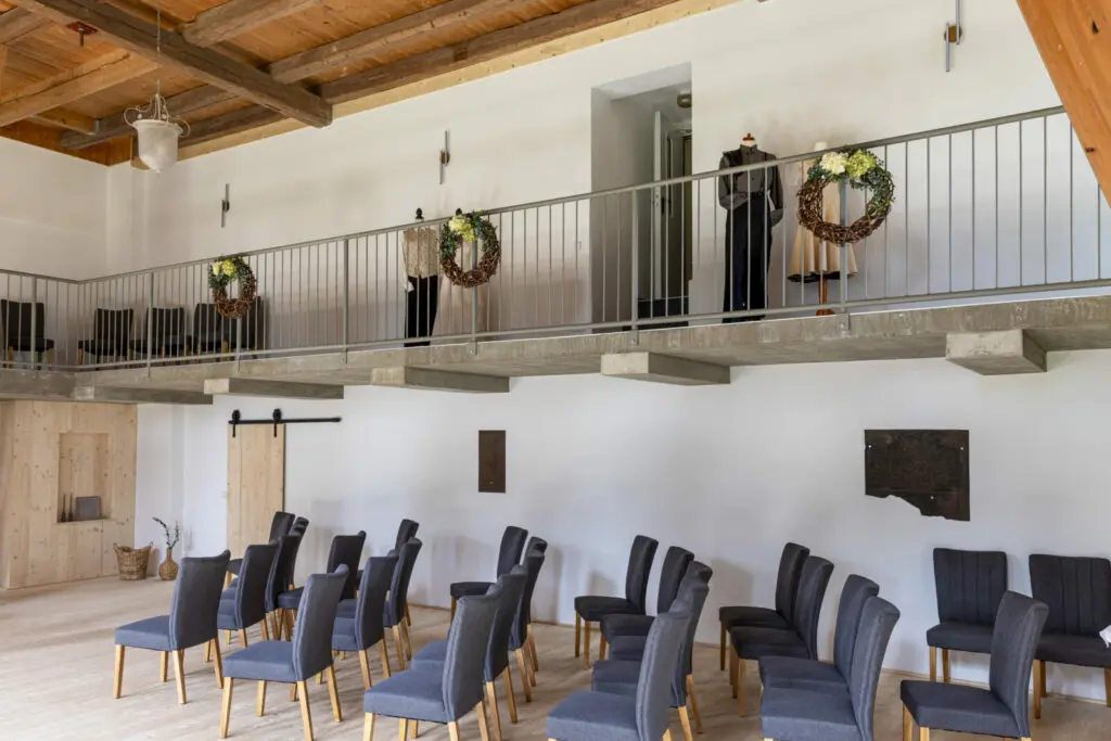 Seitliche Empore mit Dekoration und Hochzeitskleidung im Trausaal der Landpension Am Silberberg.