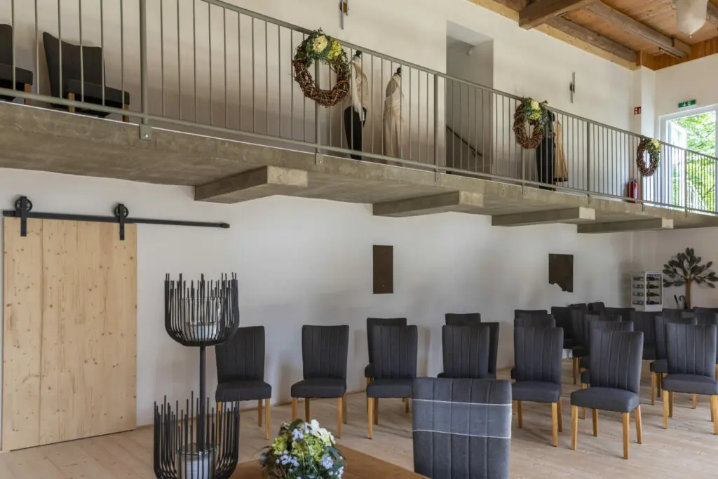 Seitliche Empore im Trausaal der Landpension Am Silberberg mit dekorierten Stühlen und Hochzeitskleidung.