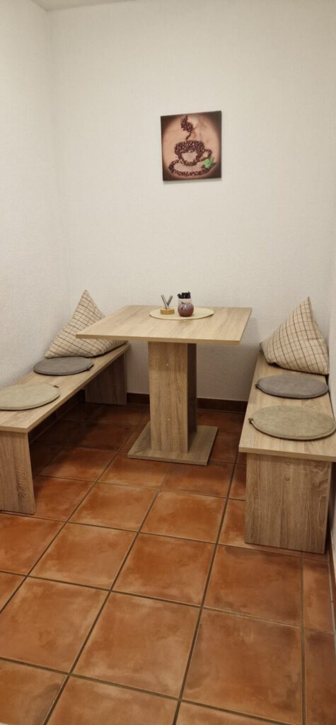 Sitzbank und Esstisch mit dezentem Wandbild – Landpension Am Silberberg in Oberwiera